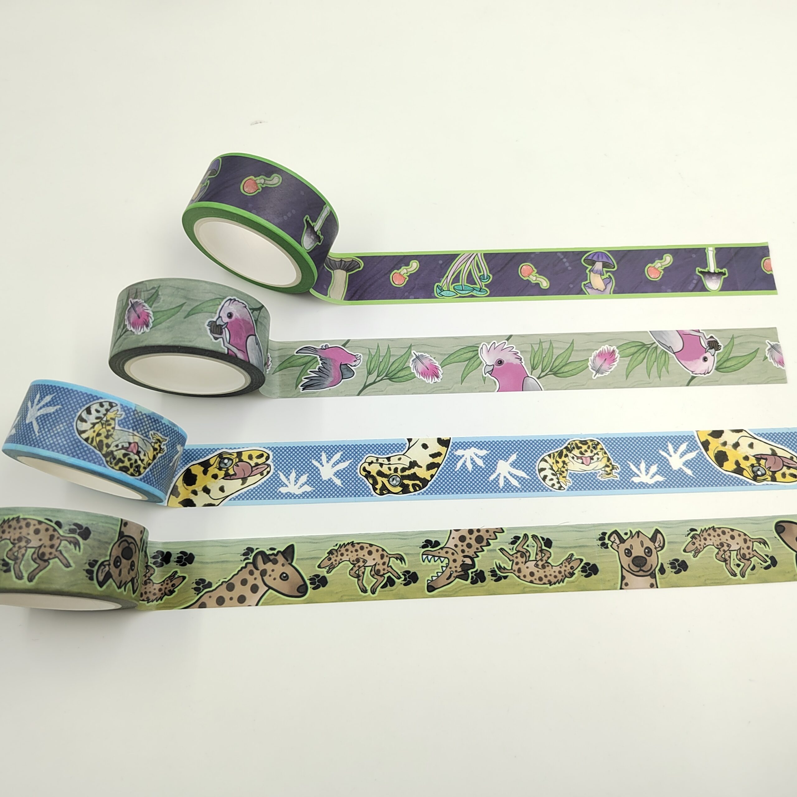 Four rolls of brightly coloured tape, decorated with cartoon animals, on a white background.